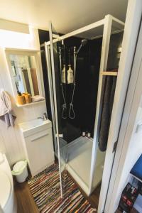 a small bathroom with a shower and a toilet at Tiny Hideaway at Cloverhills in Newham