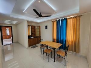 a dining room with a table and chairs and a ceiling at Sharon Holidays Near LULU in Trivandrum
