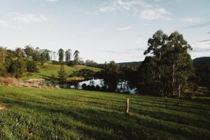 a field with a lake in the middle of a field at Little Enniskillen in Kurrajong