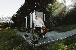 a man standing in front of a tiny house at Little Enniskillen in Kurrajong