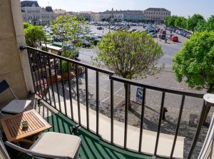 a balcony with a table and chairs and a parking lot at Sugovica Superior in Baja