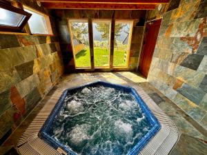 a hot tub in a room with a window at Vlasic Odmor - Villa Krajina IV & jacuzzi in Vlasic