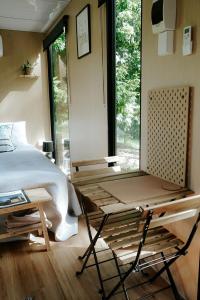Schlafzimmer mit einem Bett, einem Tisch und einem Fenster in der Unterkunft Cockatoo Cabin in Palmwoods