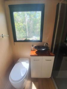 a small bathroom with a toilet and a window at Cockatoo Cabin in Palmwoods