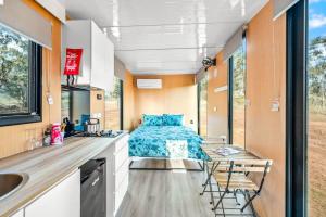 a kitchen with a bed in a tiny house at Cabernet Tiny House in Windeyer