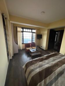 Habitación de hotel con cama grande y sofá en The G.S. Cottages en Shimla