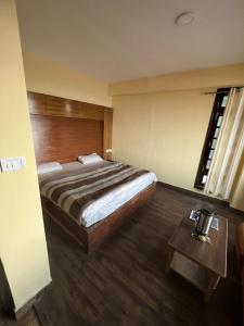 a hotel room with a bed and a table at The G.S. Cottages in Shimla