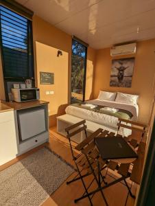 a small room with a bed and a tv at Farm Stay at Sheltered Paddock 