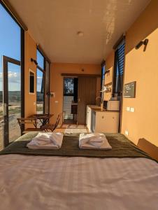 a bedroom with a large bed with two towels on it at Farm Stay at Sheltered Paddock 