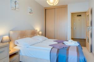 a bedroom with a bed with a teddy bear on it at Aquarius Kołobrzeg in Kołobrzeg