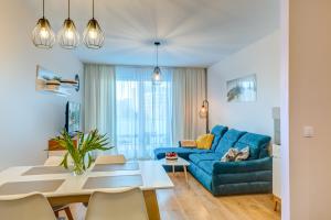 a living room with a blue couch and a table at Aquarius Kołobrzeg in Kołobrzeg