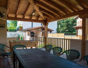 una mesa y sillas en un porche con techo de madera en Los Robles 1, en Sotillo del Rincón