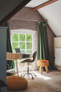 um quarto com uma secretária, uma cadeira e uma janela em Hidden Hayloft em Holmesfield