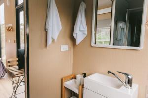 uma casa de banho com um lavatório branco e um espelho. em Rose Hill em Neerim South