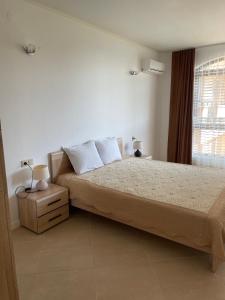 Schlafzimmer mit einem Bett und einem Fenster in der Unterkunft Oasis club apartments in Lozenets