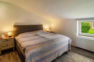 a bedroom with a bed and a window at Krummes Häusschen an der Nordsee in Großheide +16 photos
