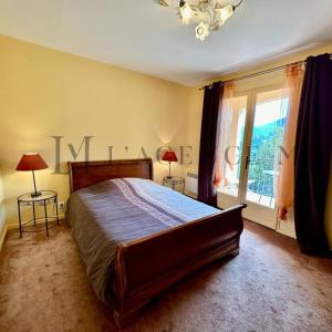 a bedroom with a large bed and a window at Villa ALTORE in Calenzana