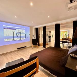 a bedroom with a large screen on the wall at Villa ALTORE in Calenzana