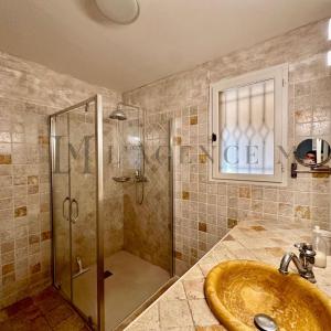 La salle de bains est pourvue d'une douche et d'un lavabo. dans l'établissement Villa ALTORE, à Calenzana