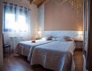 a bedroom with a bed with white sheets and a window at Los Robles 2 in Soria