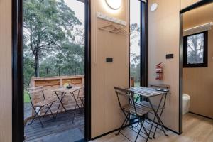 a room with a balcony with a table and chairs at Prunus Hideaway 