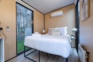 a large bed in a room with a large window at Prunus Hideaway 