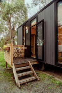 a black tiny house with a wooden deck at Prunus Hideaway 