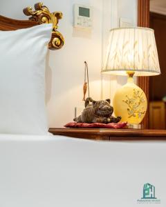 uma lâmpada sobre uma mesa ao lado de uma cama em Paradise Suites Trich Sai em Hanói