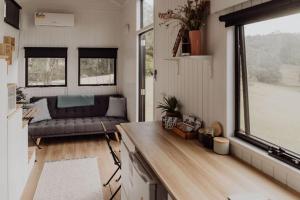 salon z kanapą i oknem w obiekcie Hill Creek Tiny House w mieście Perwillowen