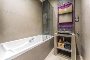 ein Badezimmer mit einer Badewanne und einem Waschbecken in der Unterkunft Appartement Luxueux avec Grande Terrasse in Charenton-le-Pont