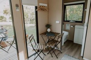 uma pequena casa com uma mesa e cadeiras numa casa de banho em Nomad Nation em Mount Perry