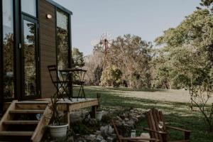 ein Haus mit zwei Stühlen, die draußen sitzen in der Unterkunft Nomad Nation in Mount Perry