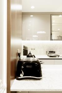 Un grille-pain est installé sur un comptoir dans la cuisine. dans l'établissement Holland Park Residence, à Londres