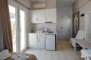 a kitchen with white cabinets and a table in a room at Fantastic Matala 1 in Matala