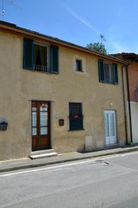a building with green shuttered windows and a door at Rifugio al mare della Versilia in Strettoia