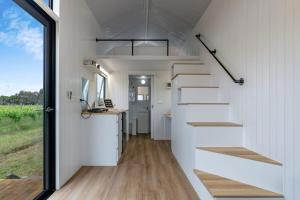 a tiny house with a staircase and a kitchen at Vineyard Retreat in Toolleen