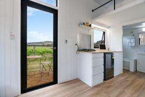 eine Küche mit einer Theke und eine Tür mit einem Fenster in der Unterkunft Vineyard Retreat in Toolleen