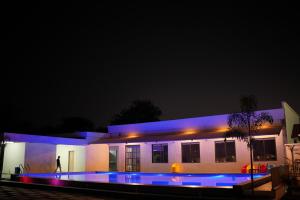 a house with a swimming pool at night at THE ROYAL YARDS RESORT in Bhopal