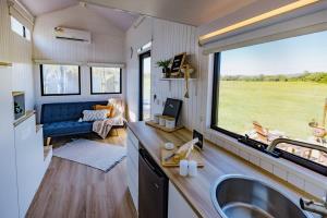 a kitchen and living room in a tiny house at Blackiron Tiny House 