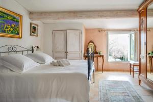 um quarto com uma grande cama branca e uma janela em Clos des Hérissons - Chambres - Piscine & jardin em Lauris