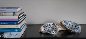 una pila de libros sentados junto a una mesa con dos sombrillas en ootmen, en Wolphaartsdijk