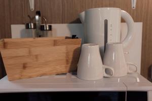a white coffee maker and two white cups on a counter at Hidden Camp Pie Creek in Gympie