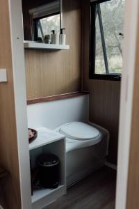 a small bathroom with a toilet and a window at Hidden Camp Pie Creek in Gympie