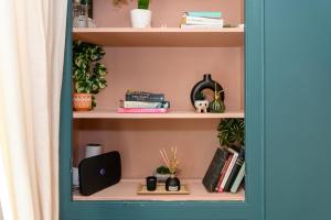 a book shelf with books and other items on it at Joseph Suite by Koya Homes in Barry