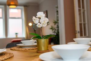 stół z wazonem z kwiatem w obiekcie Joseph Suite by Koya Homes w mieście Barry