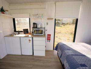 a small kitchen with a sink and a microwave at Little Argyle Tiny House in Coonabarabran