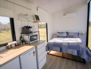 ein Schlafzimmer mit einem Bett in einem kleinen Zimmer in der Unterkunft Little Argyle Tiny House in Coonabarabran