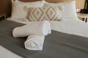 un mucchio di asciugamani seduti sopra un letto di The Stables a Palmwoods