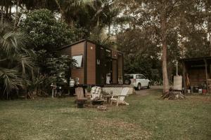 una casa pequeña en un patio con mesa y sillas en The Stables en Palmwoods