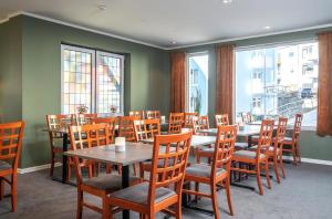 un comedor con mesas, sillas y ventanas en Thon PartnerHotel Storgata, en Kristiansund